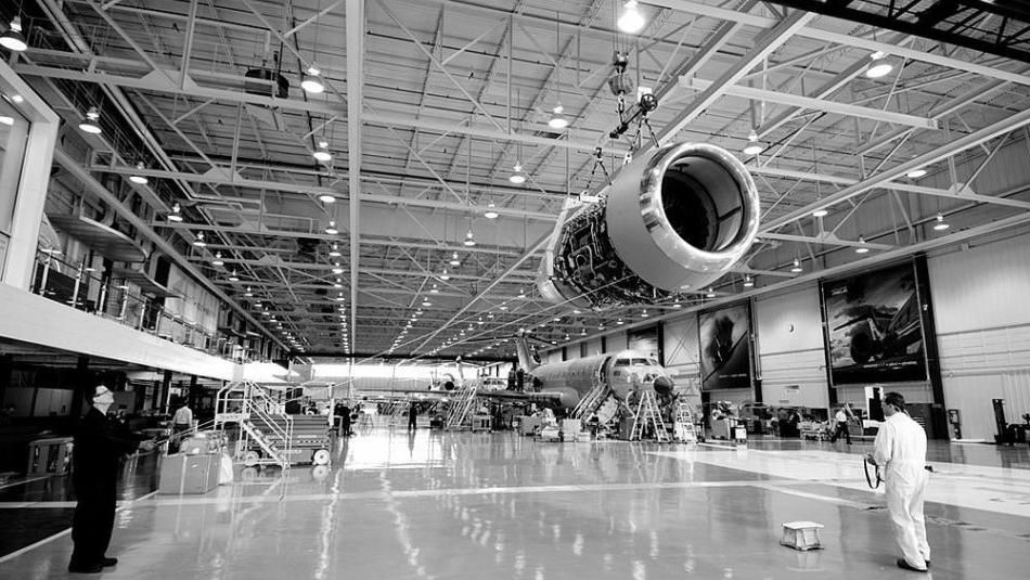 Workers at Bombardier Aerospace examine an aircraft engine nacelle