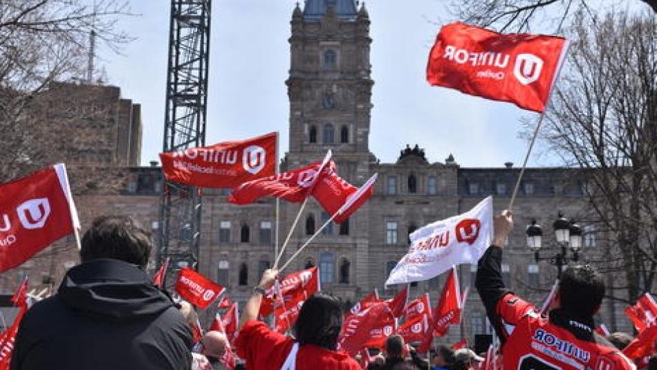 Vu d'arriere, 在魁北克市的国会山上，unifor成员举着旗帜集会.